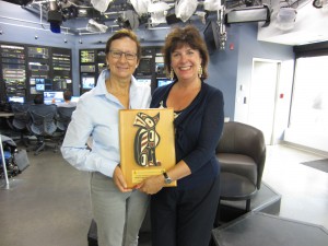 Daphne Goode of Shaw TV South Vancouver Island receives Swiftsure's 2014 sponsor plaque from Charlotte Gann.